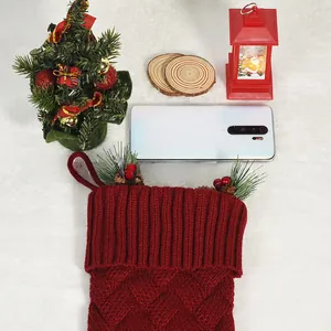 Détail de chaussette de Noël en tricot rouge avec cônes de pin et baies