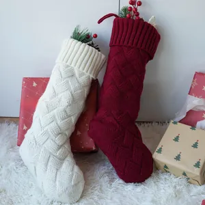 Gros plan sur des chaussettes de Noël en tricot crème et rouge foncé à torsades
