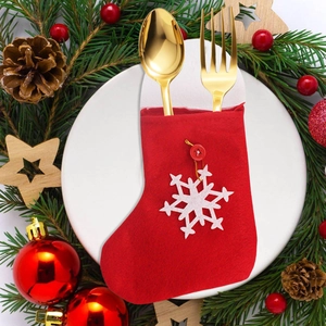 Mini red felt Christmas stocking cutlery holder with snowflake applique on a plate