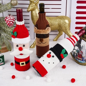 Detail of knitted Santa Snowman and Reindeer wine bottle covers for Christmas table setting