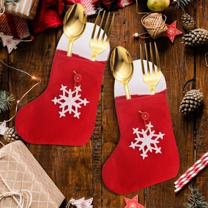 Christmas snowflake stocking cutlery holders on a festive wooden table with warm lights