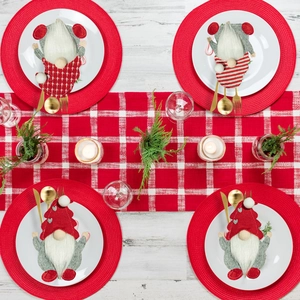 Christmas gnome cutlery holders set on white plates with festive dining table decor
