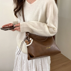 Brown faux leather tote bag detail with horse charm and gold metallic logo