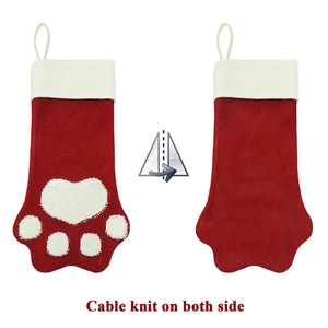 Red and white cable knit Christmas stocking with white plush paw print design