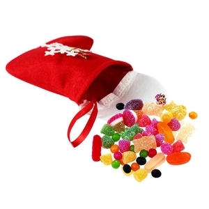 Close-up of red velvet Christmas gift bag with white snowflakes and assorted sugar candies