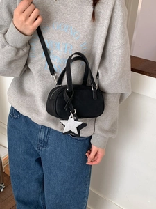 Retro black Boston pillow bag with star pendant shown on model in a casual outfit