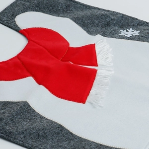 Macro detail of Christmas penguin toilet seat cover with red scarf and snowflake