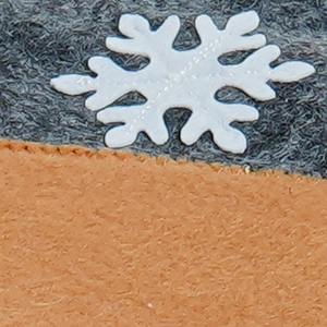 Close-up of winter accessory with orange and grey knit fabric and snowflake patch