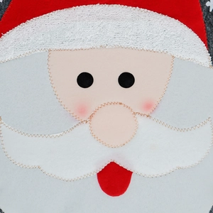 Detailed close-up of Santa Claus fabric ornament with embroidered textures and stitching