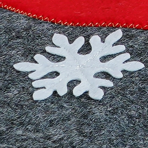 Macro shot of red felt Christmas stocking with white snowflake applique and gold stitching