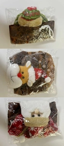 Three Christmas drawstring gift bags featuring Santa, reindeer and knit hat in packaging