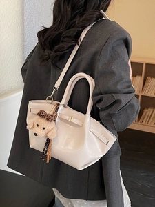 Schicke beige Ledertasche mit Hund-Anhänger an der Schulter für modischen Alltags-Look