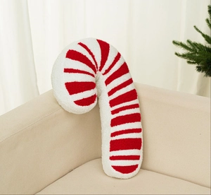 Detail eines rot-weiß gestreiften Zuckerstangen-Plüschkissens auf einem Sofa