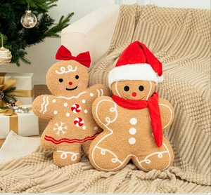 Detailed view of gingerbread plush pillows with festive bows and hats on a cozy blanket