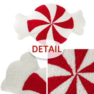 Detalle de cojín de peluche en forma de caramelo con textura de tela sherpa roja y blanca