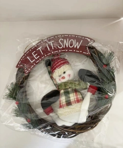 Detail van kerstkrans met sneeuwpop, bessen en Let It Snow banner in plastic verpakking