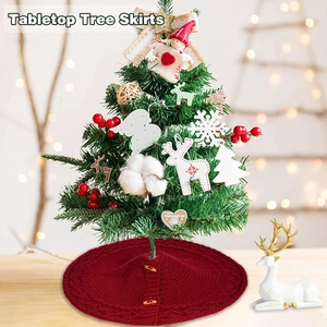 Detail of red knit mini tree skirt with cable texture and wooden buttons for tabletop trees