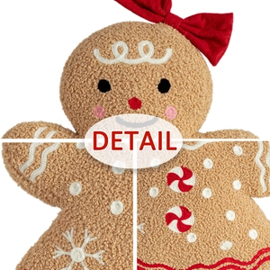 Close-up of plush gingerbread man toy showing soft teddy fleece and red bow detail