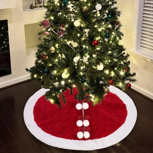 Red knit Christmas tree skirt with white faux fur trim and pom-pom bow ties