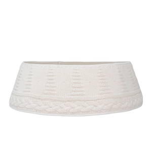 White knitted Christmas tree skirt featuring classic cable knit and embossed tree patterns