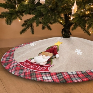 Dettaglio del tappeto per albero di Natale con Babbo Natale e ricamo HO HO HO rosso