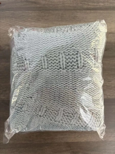 Close-up of grey knitted fabric with thick texture in transparent plastic packaging