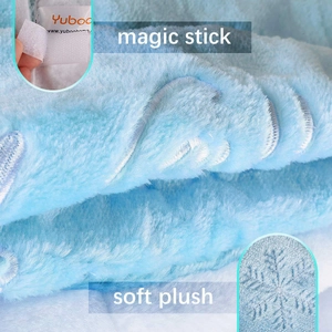 Detail of light blue plush fabric showing snowflake embroidery and magic stick closure