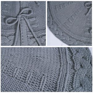 Gray knitted Christmas tree skirt with cable knit pattern and cozy wool bow detail