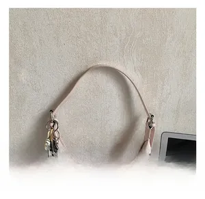 Detail of light pink hobo bag with pebble leather texture and cute chocolate pendant