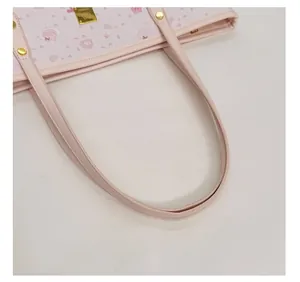 Detail of pink tote bag showing reinforced faux leather handles with golden metal rivets