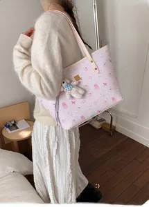 Detail of light pink tote bag with rabbit prints and a white plush bear charm
