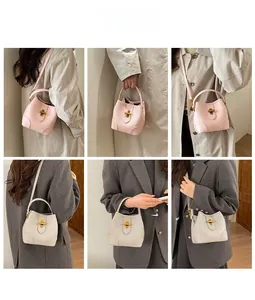 Detail shots of minimalist bucket bag in pink and beige with golden cylindrical locks