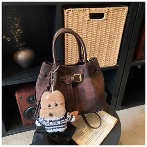 Nahaufnahme der braunen Retro-Beuteltasche mit Lederstruktur und Teddybär-Anhänger
