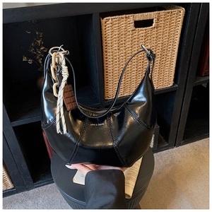 Detail of black semi-circle bag with vertical stitching and LOVE & DESIRE printing