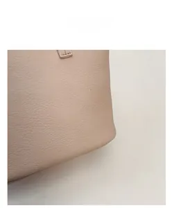 Close-up of the pebbled leather texture on a beige bucket bag with soft grain finish