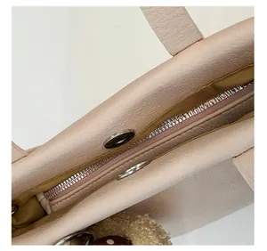 Detail of light beige leather bucket bag with metal zipper and magnetic snap closure