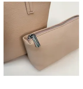 Detail of beige bucket bag with matching inner pouch featuring lychee grain texture