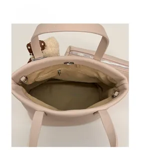 Interior layout of beige bucket bag showing main pocket, zipper pouch and polka dot charm