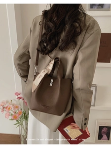 Brown bucket bag detail with litchi grain leather and decorative floral silk scarf