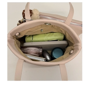 Top view of pink leather tote bag showing spacious interior with zipper and daily items