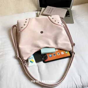 Spacious interior of this pink studded hobo bag showing tablet and daily essentials