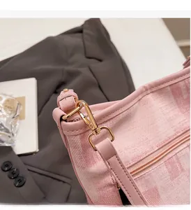 Dettaglio della borsa a secchiello in jacquard rosa con gancio in metallo dorato e pelle