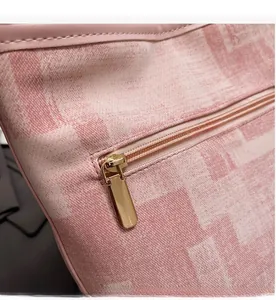 Dettaglio della borsa a secchiello rosa a quadri con cerniera in metallo dorato
