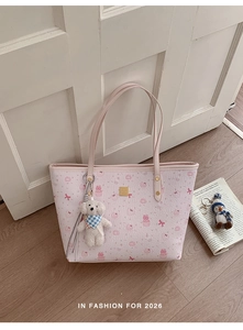 Detailed close-up of pink My Melody printed tote bag with plush bear pendant and gold logo