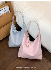 Detail of minimalist tote bags in soft pink and blue with leather knot charm detail