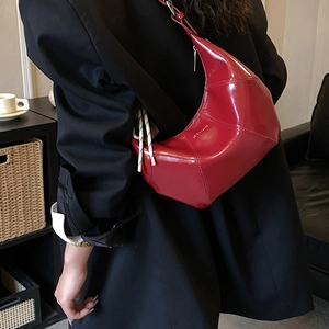 Dettaglio della borsa a mezzaluna rossa con cuciture geometriche e coulisse bianca