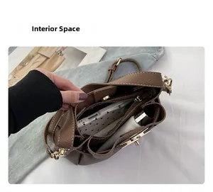Détail intérieur du sac seau en cuir grainé marron avec compartiment zippé doré