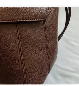 Details einer dunkelbraunen Leder-Eimertasche mit Nähten und Klappenverschluss