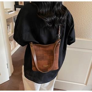 Dettaglio borsa a secchiello vintage marrone con texture scamosciata vista da dietro