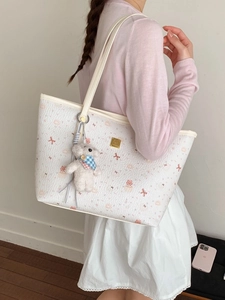 White textured tote bag with cute pink bow and cake prints and a plush bear charm
